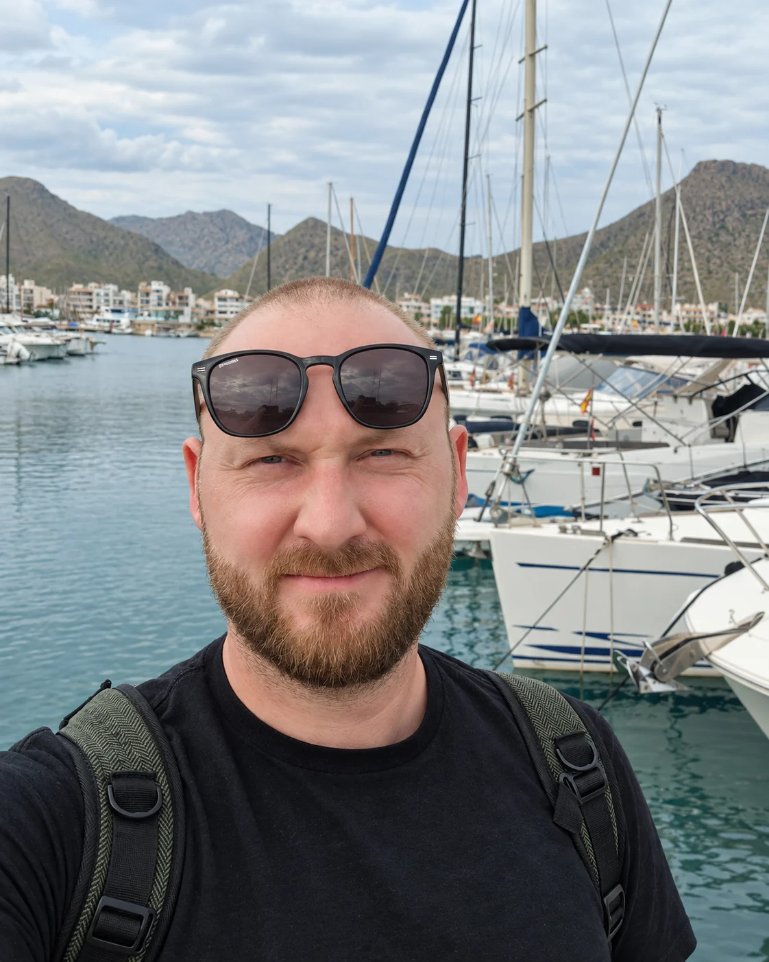 Jonas am Hafen vor Booten und Bergen